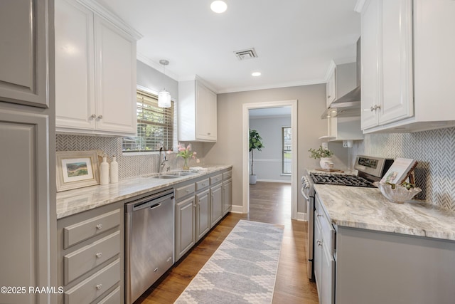 kitchen with visible vents, gray cabinetry, a sink, wood finished floors, and appliances with stainless steel finishes