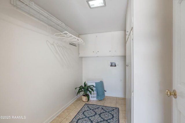 interior space with light tile patterned floors, baseboards, cabinet space, and washer hookup