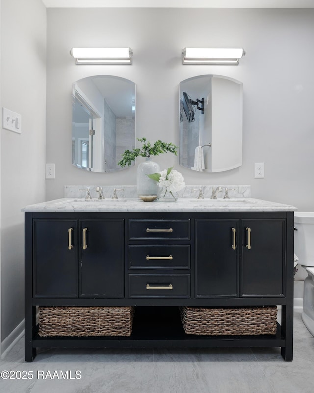 bathroom featuring double vanity, toilet, and a sink