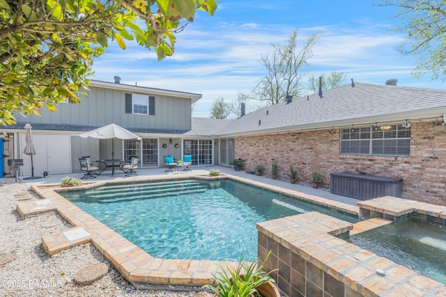 outdoor pool featuring a patio and an in ground hot tub