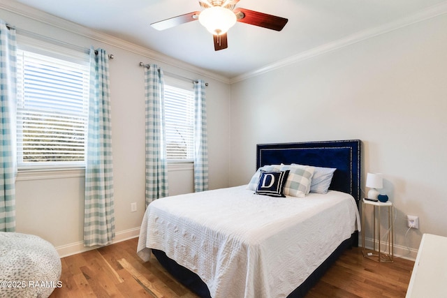 bedroom with baseboards, a ceiling fan, wood finished floors, and crown molding