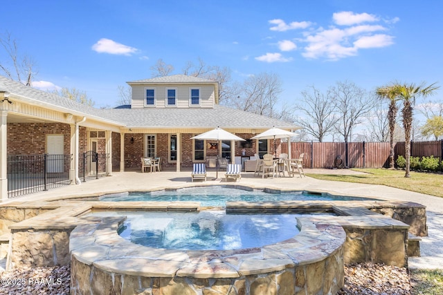 view of swimming pool featuring an in ground hot tub, a patio, and fence