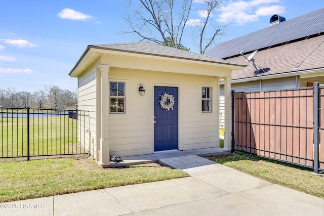 doorway to property with a yard, fence, and a shingled roof