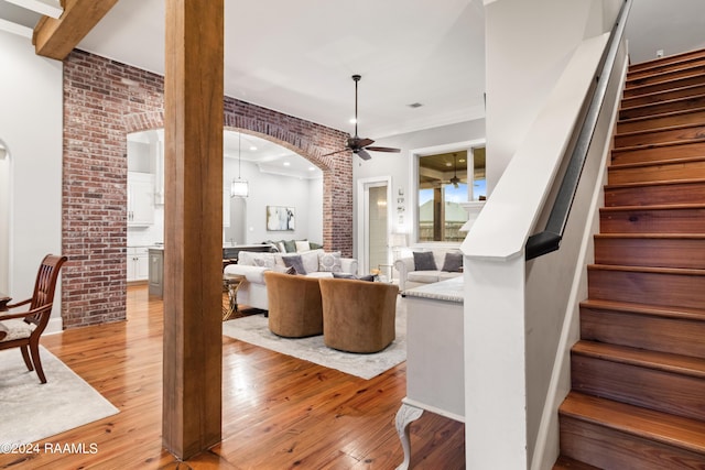 living area featuring light wood-type flooring, stairway, and ceiling fan