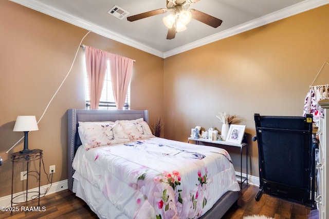 bedroom with visible vents, ornamental molding, wood finished floors, baseboards, and ceiling fan