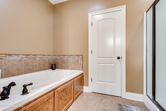 full bathroom with tile patterned flooring, a bath, and baseboards