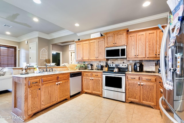 kitchen featuring a sink, decorative backsplash, appliances with stainless steel finishes, and a peninsula