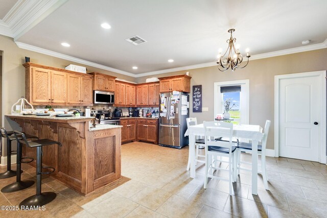 kitchen with visible vents, light countertops, a kitchen bar, appliances with stainless steel finishes, and a peninsula