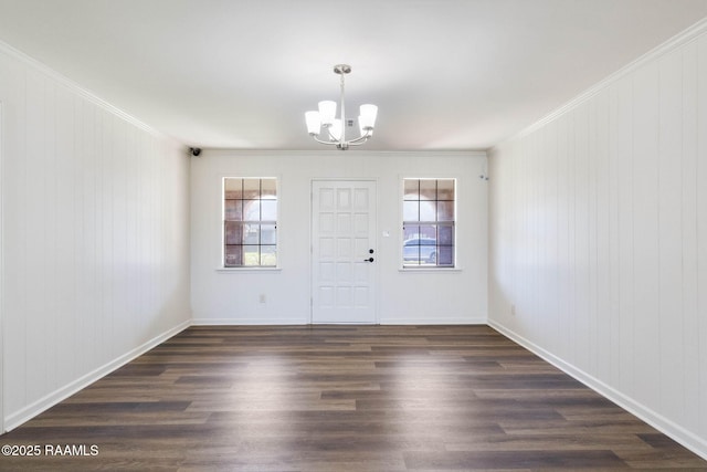 entryway featuring dark wood-style floors, a notable chandelier, baseboards, and ornamental molding