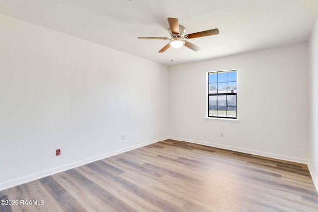 empty room featuring wood finished floors, baseboards, and ceiling fan