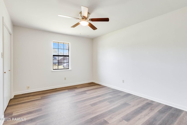 unfurnished bedroom with a closet, baseboards, wood finished floors, and a ceiling fan