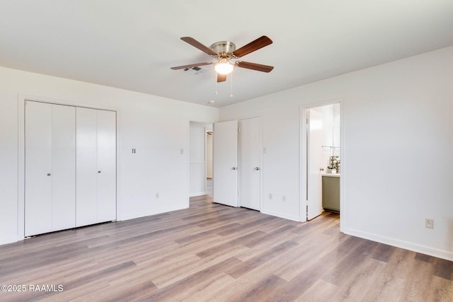 unfurnished bedroom with visible vents, light wood-style flooring, ensuite bath, a closet, and baseboards