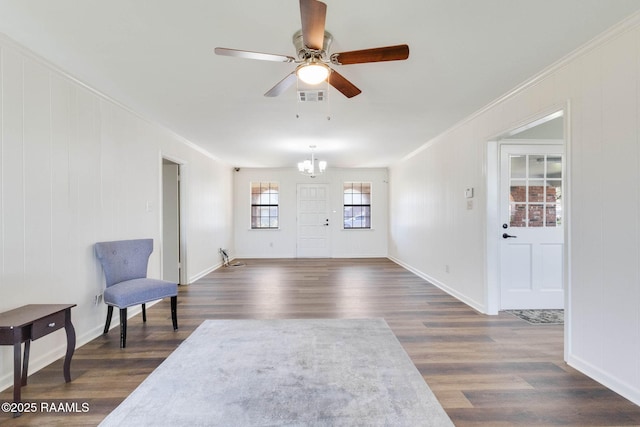 foyer entrance with visible vents, dark wood-type flooring, ornamental molding, ceiling fan with notable chandelier, and baseboards