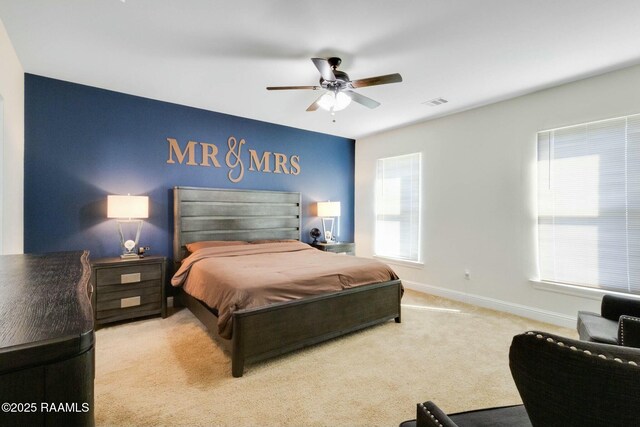 carpeted bedroom with a ceiling fan, visible vents, and baseboards