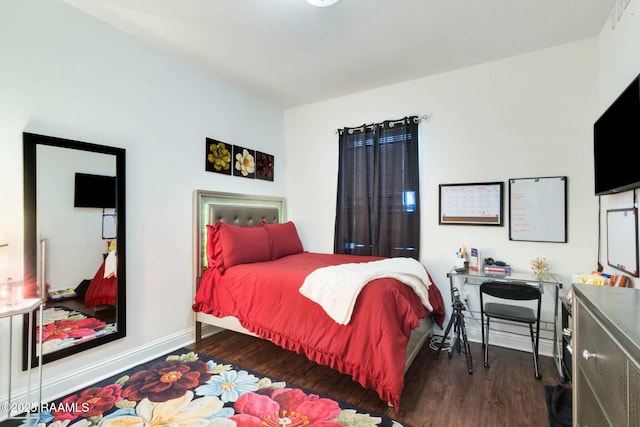 bedroom with baseboards and wood finished floors