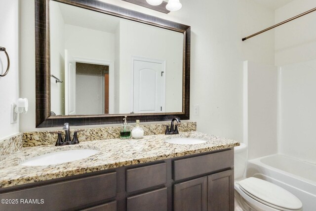 full bath with double vanity, washtub / shower combination, toilet, and a sink