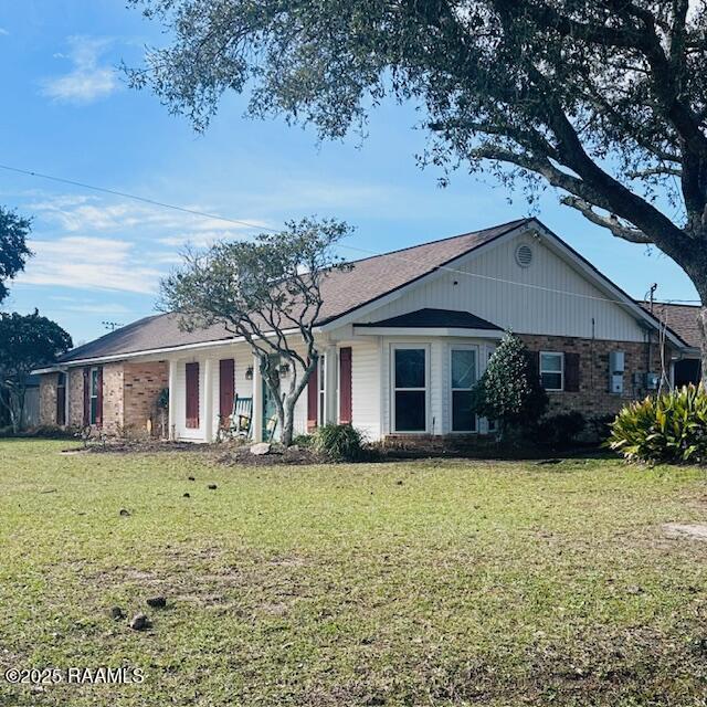 ranch-style house featuring brick siding and a front yard