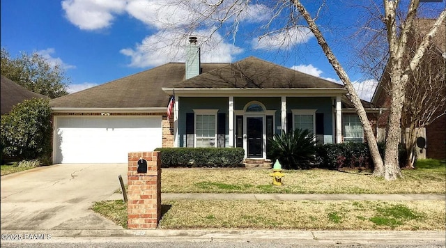 view of front of house with driveway, a porch, a chimney, a garage, and brick siding