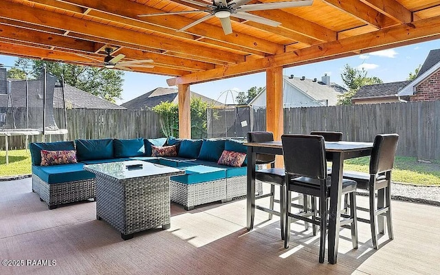 view of patio featuring a fenced backyard, outdoor lounge area, outdoor dining area, and a ceiling fan