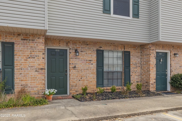 doorway to property featuring brick siding