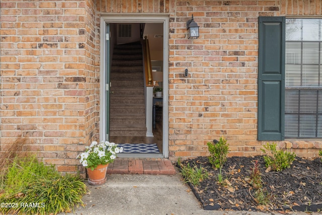 property entrance featuring brick siding