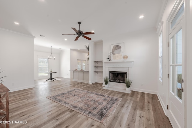 unfurnished living room featuring visible vents, baseboards, light wood-style floors, and a fireplace with flush hearth