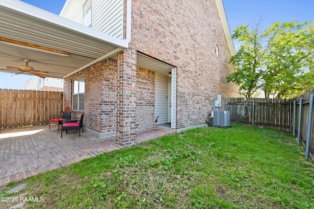 view of yard with a fenced backyard, a patio, a ceiling fan, and central AC