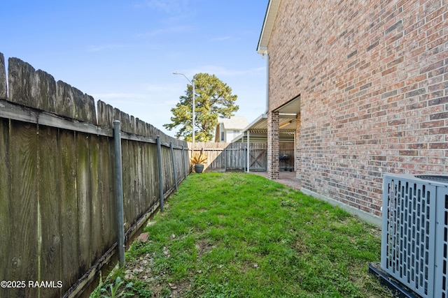 view of yard featuring central AC unit and a fenced backyard