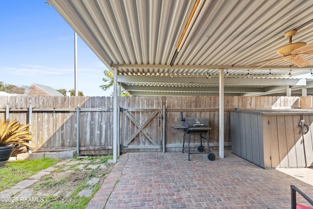 view of patio with area for grilling, ceiling fan, and fence