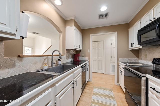 kitchen with visible vents, white cabinets, black appliances, and a sink