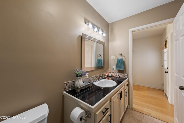 half bath with vanity, tile patterned floors, and toilet