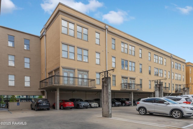 view of property featuring covered and uncovered parking