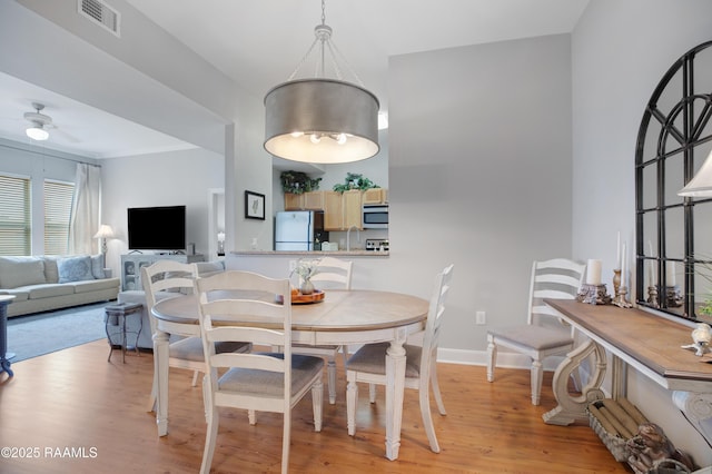 dining space featuring ceiling fan, baseboards, visible vents, and light wood-type flooring