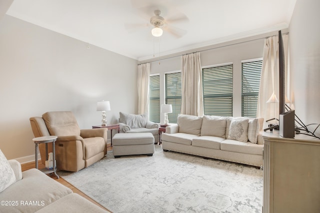 living room featuring baseboards, wood finished floors, ornamental molding, and a ceiling fan