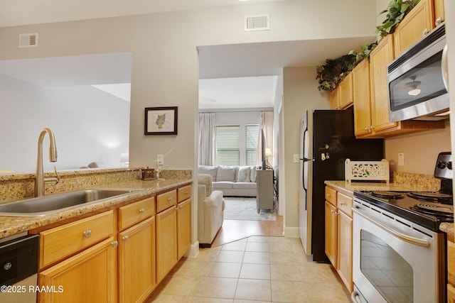 kitchen with light tile patterned floors, visible vents, appliances with stainless steel finishes, and a sink