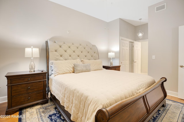 bedroom with visible vents, baseboards, and wood finished floors