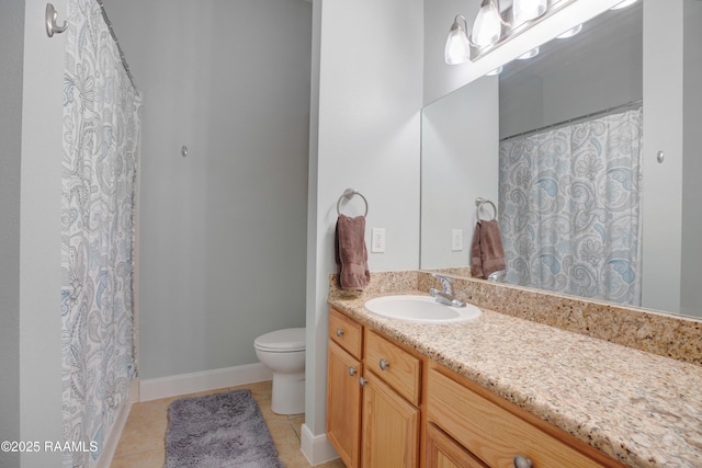 bathroom with baseboards, toilet, vanity, and tile patterned flooring