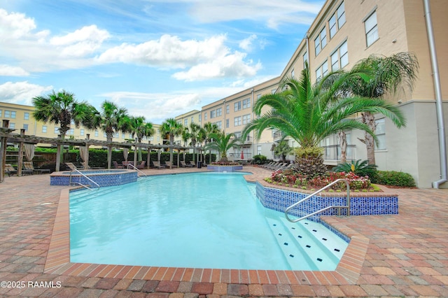 community pool featuring a patio area and a hot tub