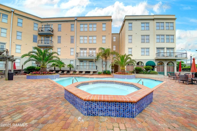 view of pool featuring a community hot tub and a patio