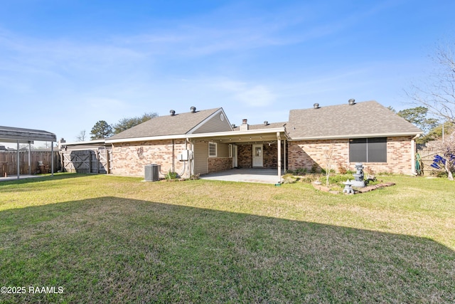 rear view of property with a lawn, central AC, and fence