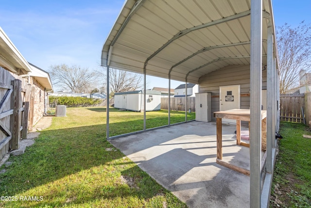 view of vehicle parking featuring a detached carport, concrete driveway, fence, and a shed