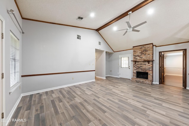 unfurnished living room featuring a brick fireplace, baseboards, light wood-style floors, a textured ceiling, and a ceiling fan