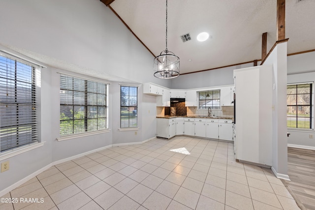 kitchen featuring light tile patterned floors, visible vents, ornamental molding, and decorative backsplash