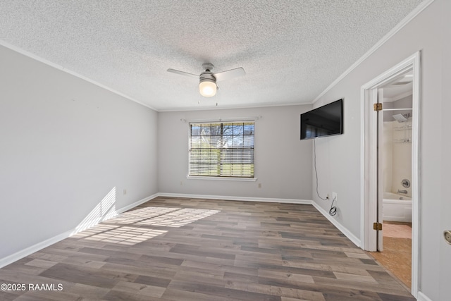 spare room featuring ornamental molding, a textured ceiling, wood finished floors, baseboards, and ceiling fan