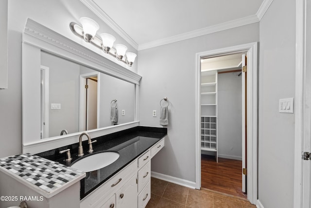 bathroom with vanity, crown molding, baseboards, and tile patterned floors