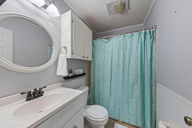 bathroom featuring vanity, a wainscoted wall, ornamental molding, a textured ceiling, and toilet