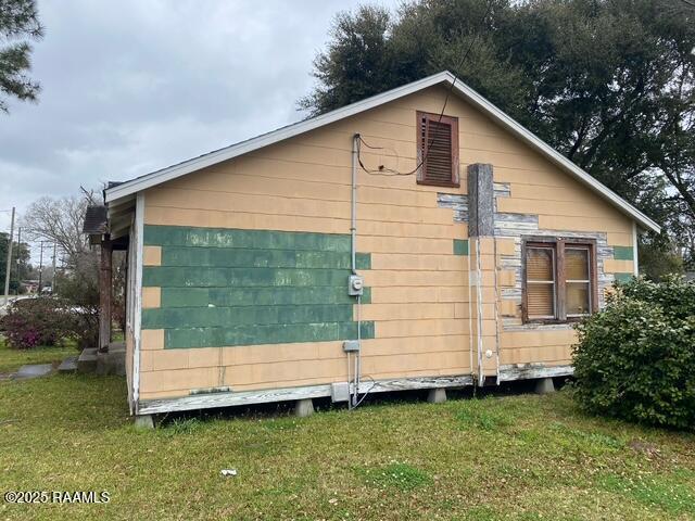view of side of home with a yard