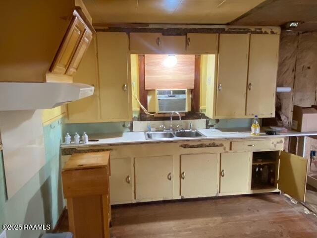 kitchen featuring cooling unit, wood finished floors, light countertops, and a sink