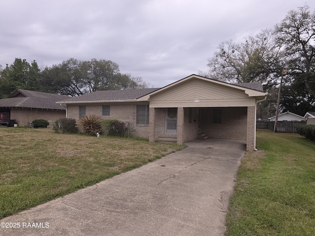 view of front facade with brick siding, driveway, a front yard, and fence