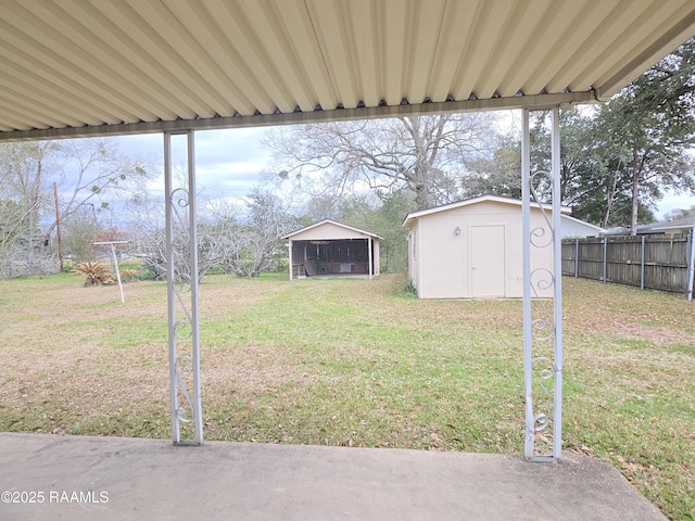 view of yard with a storage shed, an outdoor structure, and fence